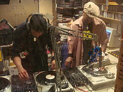 Two DJs work the turntables and mixer