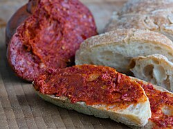 'Nduja with bread, with a piece of 'nduja sausage in the background