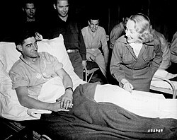 Marlene Dietrich signing a soldier's cast (Belgium, 1944)