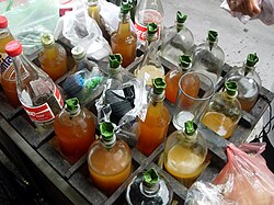 Different types of Indonesian jamu herbal medicines held in bottles