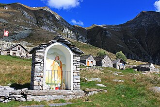 An "Alp" refers to a high elevation pasture frequented only in summer. It often includes several huts and small places of worship (here the Alpe Bardughè in Ticino).