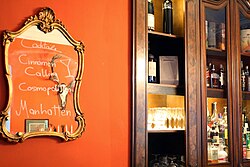 Liquor and wine bottles displayed in a cabinet behind a bar in Baden, Austria