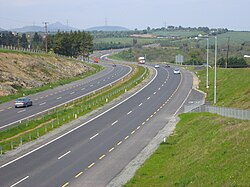 A typical modern Irish dual carriageway (opened 2004) along the N11, south of Newtownmountkennedy. On motorways, the yellow hard shoulder markings are unbroken.