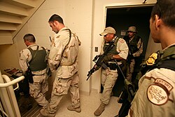 A Border Patrol Special Response Team searches a hotel room-by-room in New Orleans in response to Hurricane Katrina.