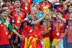 Olmo holding the FIFA World Cup Trophy after Spain won the final
