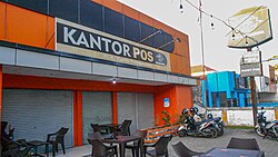 Indonesia did not adopt the Dutch language after independence. However, the Indonesian language is heavily influenced by Dutch. Seen here is kantor pos (from the Dutch postkantoor), meaning post office.