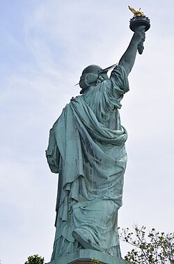 The Statue of Liberty was conceived by French abolitionist Édouard René de Laboulaye to commemorate the end of slavery in the US.[378] The initial design saw her hold a broken chain in her left hand, but American financiers were opposed to the statue acknowledging slavery; the sculptor Bartholdi retained the chains at her feet (pictured) which are barely visible.[379]
