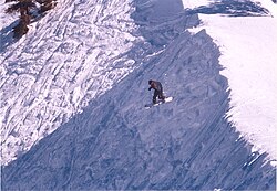 Snowboarder riding off a cornice