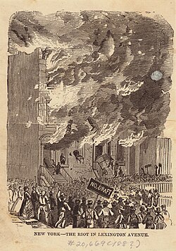 Building on fire as rioters look on, one holds a sign that says "no draft"