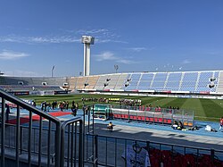 Teams and officials line up on a football pitch ready for a match.