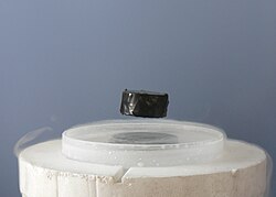 A typical phenomenon described by physics: a magnet levitating above a superconductor demonstrates the Meissner effect.