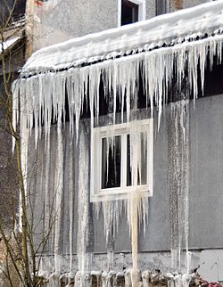 Icings resulting from meltwater at the bottom of the snow pack on the roof, flowing and refreezing at the eave as icicles and from leaking into the wall via an ice dam.