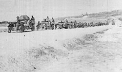 No. 12 Light Armoured Motor Battery and No. 7 Light Car Patrol with the 5th Cavalry Brigade on the road north of Aleppo. Mehemet Ali military barracks in background