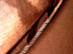 The serrations on the leading edge of an owl's flight feathers reduce noise