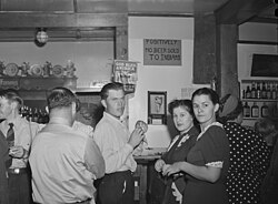 A discriminatory sign ("no beer sold to Indians") posted above a bar. Birney, Montana, 1941