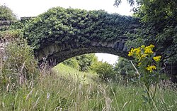 An abandoned stone bridge spans the route of the Otley and Ilkley Joint Railway through Otley, which was closed in 1965.