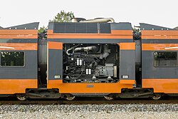 The Power Pack car of Stadler FLIRT DMU, with open bay of a diesel-generator. The Jacobs bogies under this car do not have their own traction motors, which are mounted on bogies under other cars.