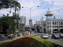The Kuala Lumpur Railway Station (right) contrasts with Keretapi Tanah Melayu (left) Administration Building, a darker, similarly Mughal-styled building. Both were designed by A. B. Hubback