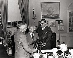 Israeli Prime Minister Ben-Gurion (center) gives President Truman (left) a Hanukkah menorah as ambassador Abba Eban watches in the Oval Office