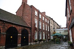 The courtyard and range of the Angel and Royal, pictured here, are 18th-century additions to the mediæval Inn, replacing portions of the earlier Inn, such as external stairways, some galleries, barns to the rear, and a timber-built wing to the right of the front.[13]