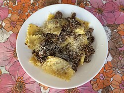 A plate of dry Pavese agnolotti, a type of stuffed pasta, with a Pavese stew-based sauce
