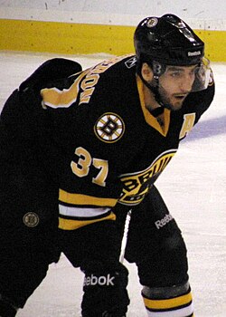Patrice Bergeron in all black Bruins third jersey in 2011, with exchanged "spoked-B" and shield logo locations