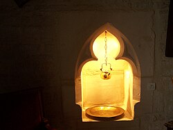 A 14th-century lavabo as a niche recessed into the side wall of a sanctuary in Amblie, Normandy