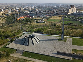 Spiky monument perched on a hill above a large city