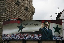 Billboard with a portrait of Bashar al-Assad and the text 'Syria is protected by God' on the old city wall of Damascus in 2006