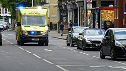 Mercedes-Benz Sprinter ambulance used by the NHS with blue lights and sirens on.