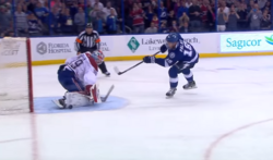 A skater taking a penalty shot, with a referee in the background. A referee may award a player with a penalty shot if they assess an infraction stopped the player from a clear scoring opportunity.