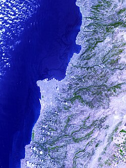 Image from space showing Jiyyeh oil slick in darkest blue, picture centered on Beirut. The largest oil spill in the history of the Mediterranean, it was caused by an Israeli air strike on Jiyeh power station[270] on 10 August 2006.