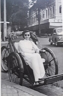 A lady in a traditional Áo dài on an originally-designed xích lô, 1939