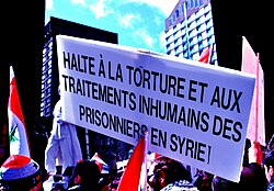 Demonstration in Montreal in solidarity with the people of Syria. The sign reads: "Stop torture and inhumane treatment of prisoners in Syria!"