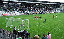 A player taking a penalty kick from inside the penalty area.