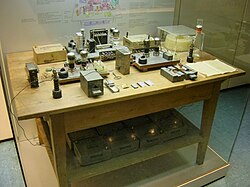 This was touted for many years as the table and experimental apparatus with which Otto Hahn discovered nuclear fission in 1938. The table and instruments are representative of the ones used, but not necessarily the originals, and would not have been together on the one table in the same room. Pressure from historians, scientists and feminists caused the Deutsches Museum to alter the display in 1988 to acknowledge the role of Meitner, Frisch and Strassmann.[99]