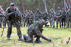 A German infantryman stands at the ready with his Heckler & Koch G36 during a practice exercise in 2004 as U.S. troops watch in the background. All rifles in the photo are equipped with blank firing adapters.