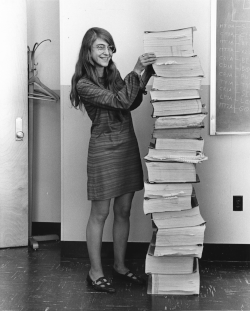 Margaret Hamilton standing next to the navigation software that she and her MIT team produced for the Apollo project