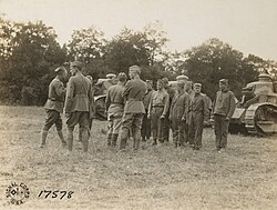 Tank Corps School near Langres, France, 15 July 1918. Tank crew receiving instruction from officers, from left to right: Captain Ranulf Compton, Chief Instructor, and Lieutenant Colonel George S. Patton (center, with back towards the camera), the Commanding Officer