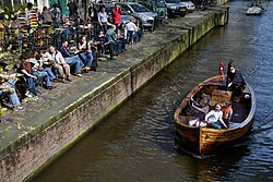 A family rides a boat in one of the canals of Amsterdam.
