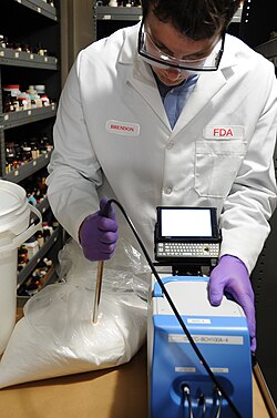 A U.S. Food and Drug Administration scientist uses a portable near-infrared spectroscopy device to inspect lactose for adulteration with melamine