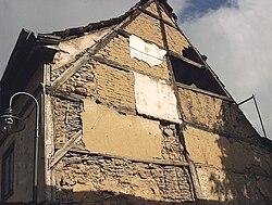 Half-timbered wall with three kinds of infill: wattle and daub, brick, and stone. The plaster coating which originally covered the infill and timbers is mostly gone. This building is in the central German city of Bad Langensalza.