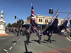 The Union Jack, New Zealand flag and Australian flag in an Anzac Day march in 2017