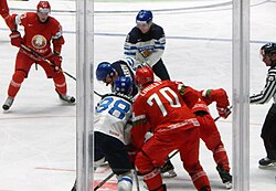 Skaters from the Finnish and Belarusian men's ice hockey teams shortly after a face-off during the 2016 IIHF World Championship. The IIHF is an annual national team tournament.