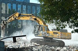 Excavator (a type of heavy equipment commonly used at construction sites and roadworks) demolishing the remnants of the pre-war Postal Train 0880Station (Dworzec Pocztowy) at Jerozolimskie Avenue, Poland