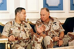Schwarzkopf talks with General Colin Powell, Chairman of the Joint Chiefs of Staff, during a press conference regarding the Gulf War