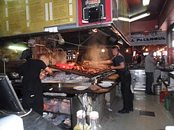 Line cooks grilling sausages, asado, and offal in Mercado del Puerto