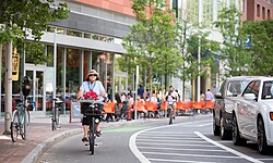 Class IV separated bike way in Cambridge, Massachusetts. The physical division for this particular bike way is the line of parked cars.