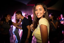 A crowd dancing at a nightclub in 2018. Highlighting the social interaction and vibrant lighting typical of modern nightlife venues.