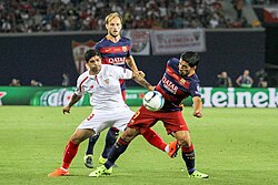 Barcelona's Luis Suárez dribbling past Banega in the 2015 UEFA Super Cup